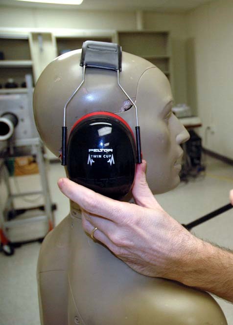 A KEMAR head-and-torso simulator with hearing protection earmuffs being tested.
